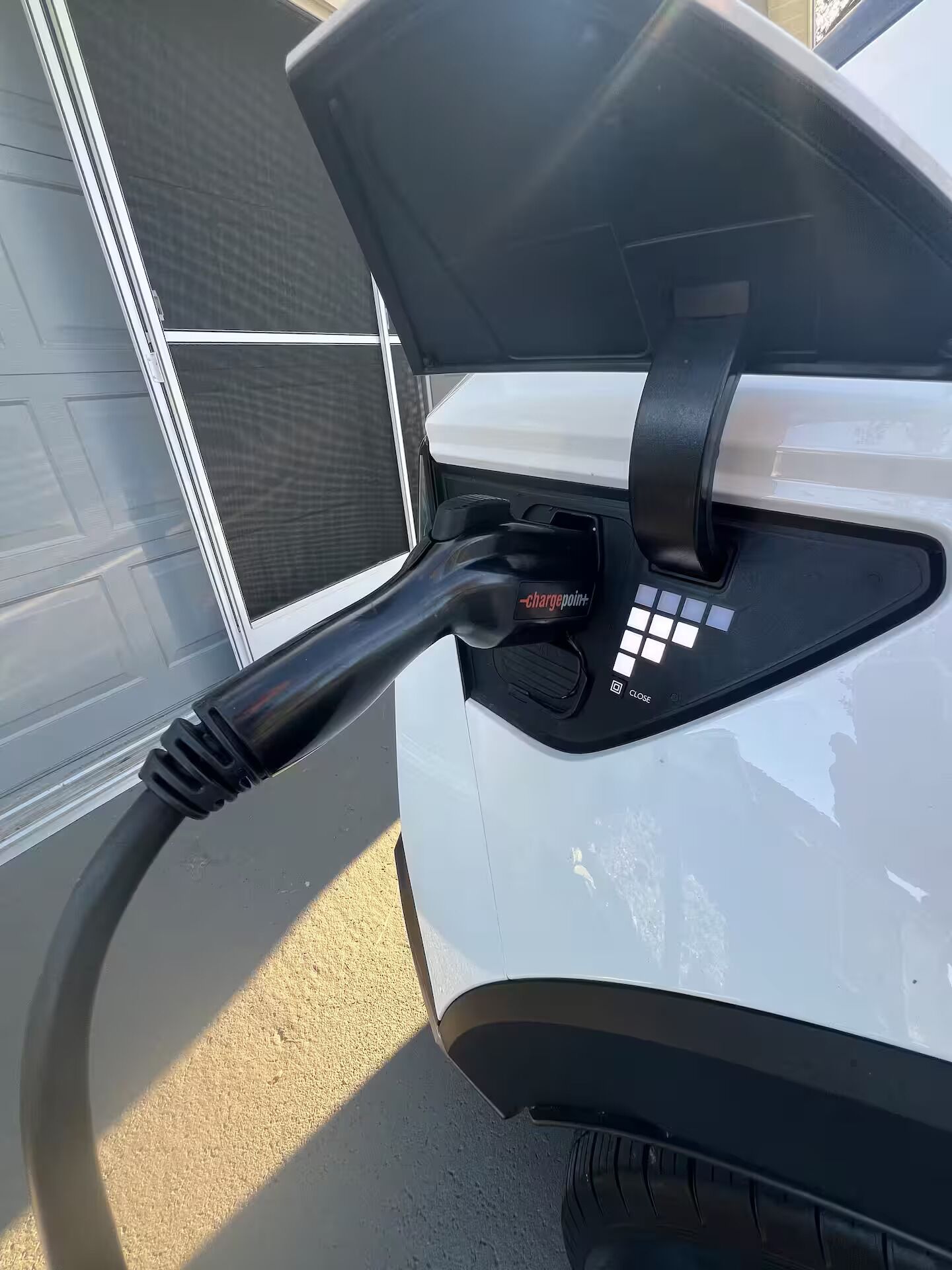 A car charging at a station with a visible "chargepoint+" label.