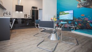 Une cuisine moderne équipée d’un four à micro-ondes, d’une machine à café et d’un coin repas avec une table et des chaises.