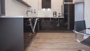 Une cuisine moderne dotée d’un îlot central, de tabourets de bar et d’une machine à café.
