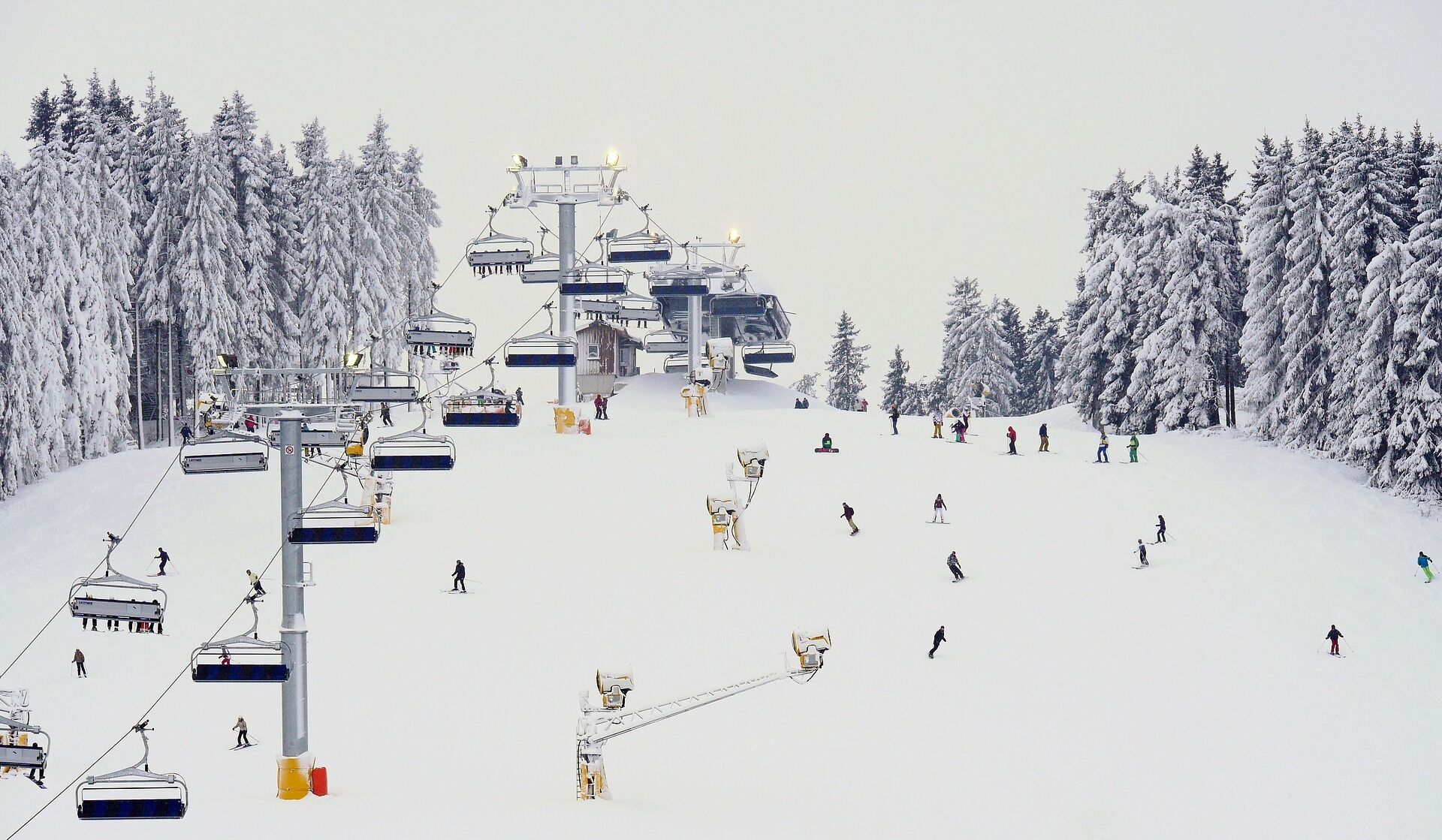Un télésiège avec plusieurs sièges et une pente enneigée où l’on peut skier.