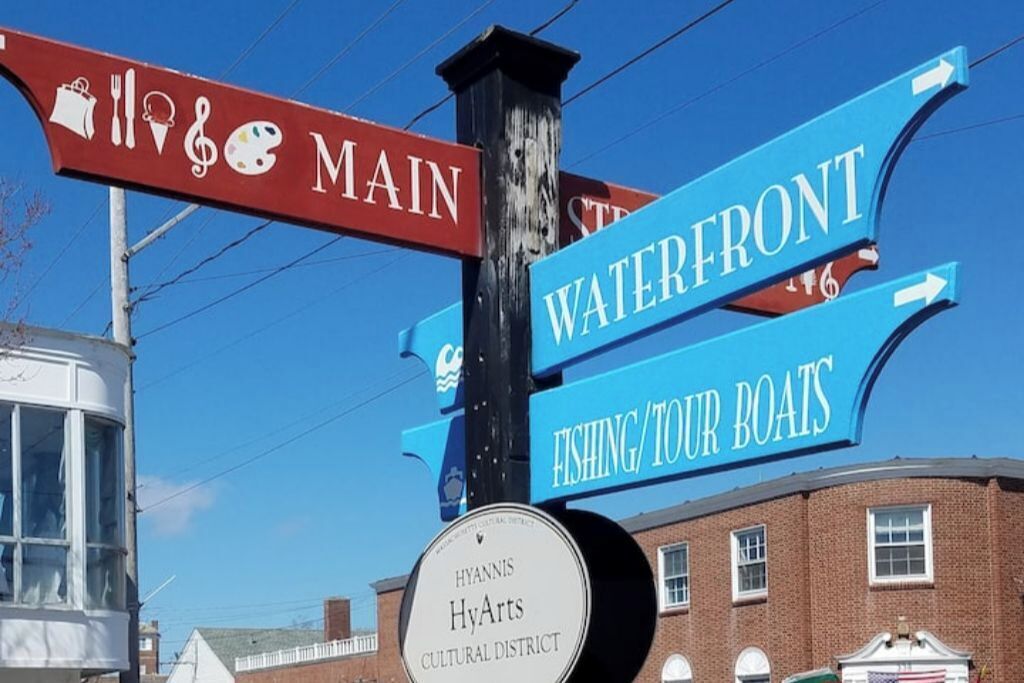 A directional signpost with multiple arrows pointing to different locations, including 'Main', 'Waterfront', and 'Fishing/Tour Boats'.