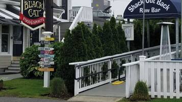 Un restaurant appelé « The Black Cat Food & Spirits », avec un panneau indicateur indiquant les directions vers différents endroits.