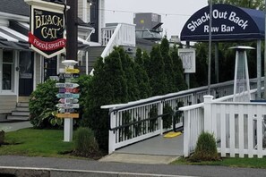 A restaurant named 'The Black Cat Food & Spirits' with a signpost indicating directions to various locations.
