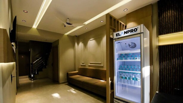 Pasillo de hotel con zona de estar, minibar y una escalera.