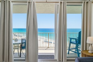 A balcony with a view of the beach and ocean.