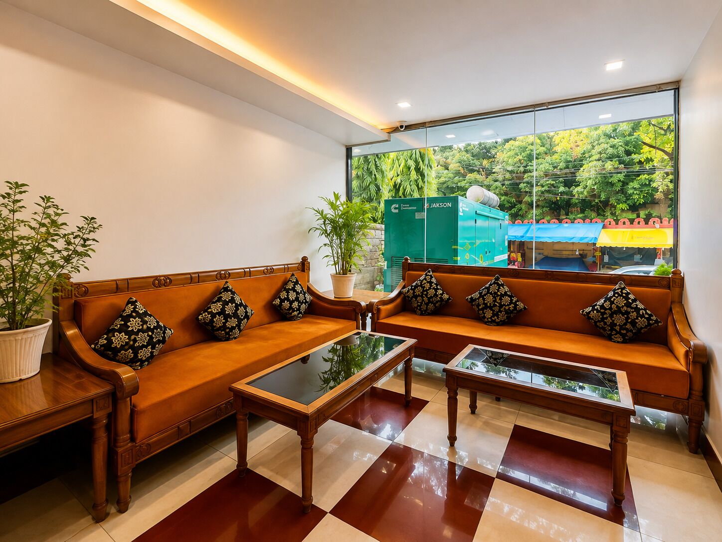 Un área de espera moderna con un conjunto de sofás, una mesa de centro y una planta en maceta.