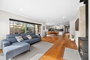 A modern living room with a grey sectional sofa, wooden flooring, and a fireplace.