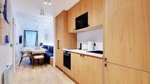 Une cuisine moderne avec des meubles en bois, un four à micro-ondes encastré et un coin repas comprenant une table et des chaises.