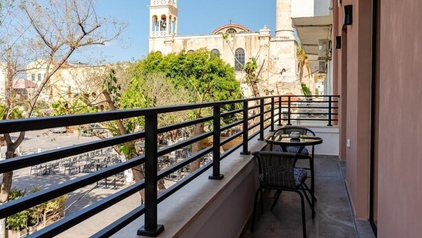 A balcony with a view of a historic church with a bell tower. - Spacious Luxury apt , old Town (Chania)