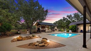 A backyard with a swimming pool, a barbecue area, and a covered patio. - El Ranchito (Golf Included through May 2027): 4  BR, 4.5  BA House in Concan, Sleeps 20 (Concan)