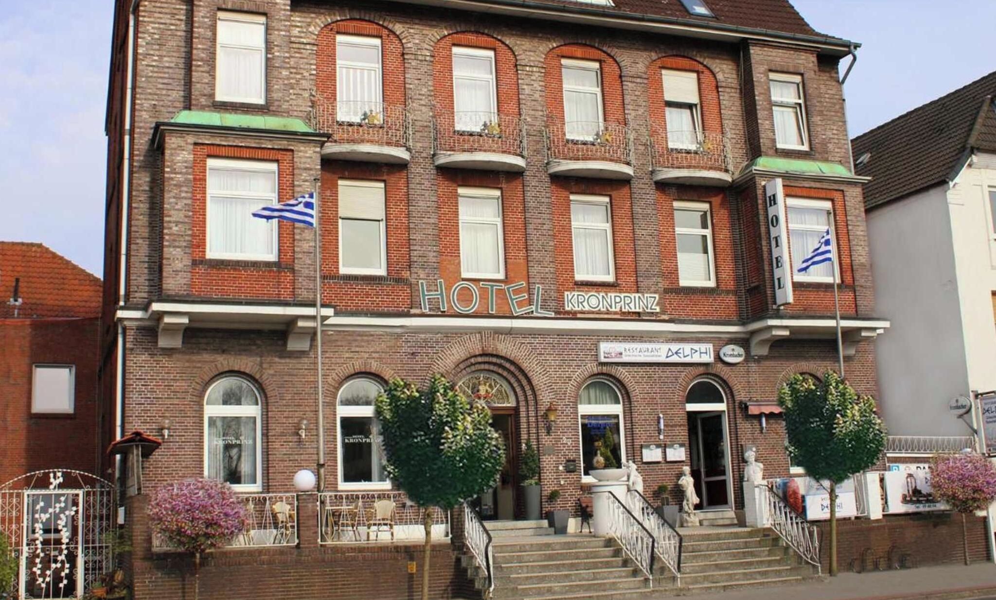 Ein zweistöckiges Hotel mit einer traditionellen Ziegel Fassade, zahlreichen Fenstern und einem Schild, das es als Hotel kennzeichnet.