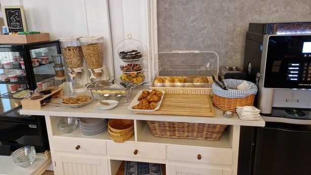 A breakfast buffet with various food items and a coffee machine. - Hotel Kronprinz  (Emden)