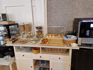 A breakfast buffet with various food items and a coffee machine. - Hotel Kronprinz  (Emden)