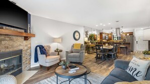 A modern living room with a fireplace, a dining area, and a kitchen. - Blue Royale Retreat - Condo for 6 (Branson)