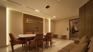 A modern hotel lobby with a dining area featuring a round table and chairs, a sofa, and a reception desk. - New Gold's Pyramids Hotel (Giza)