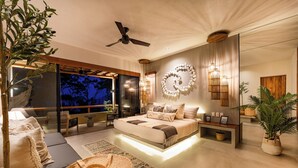 A modern bedroom with a large bed, a ceiling fan, a wall-mounted light fixture, and a view of the outdoors. - Stylish Escape | Private Plunge Pool | Oceanviews (Huatulco)