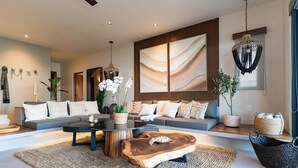 A modern living room with a sofa, coffee table, and decorative plants. - Stylish Escape | Private Plunge Pool | Oceanviews (Huatulco)