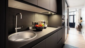 A modern kitchen with a stainless steel sink, a bowl of fruit, and a built-in oven. - Chic Apartment - 2br/6p - Pantheon (Paris)