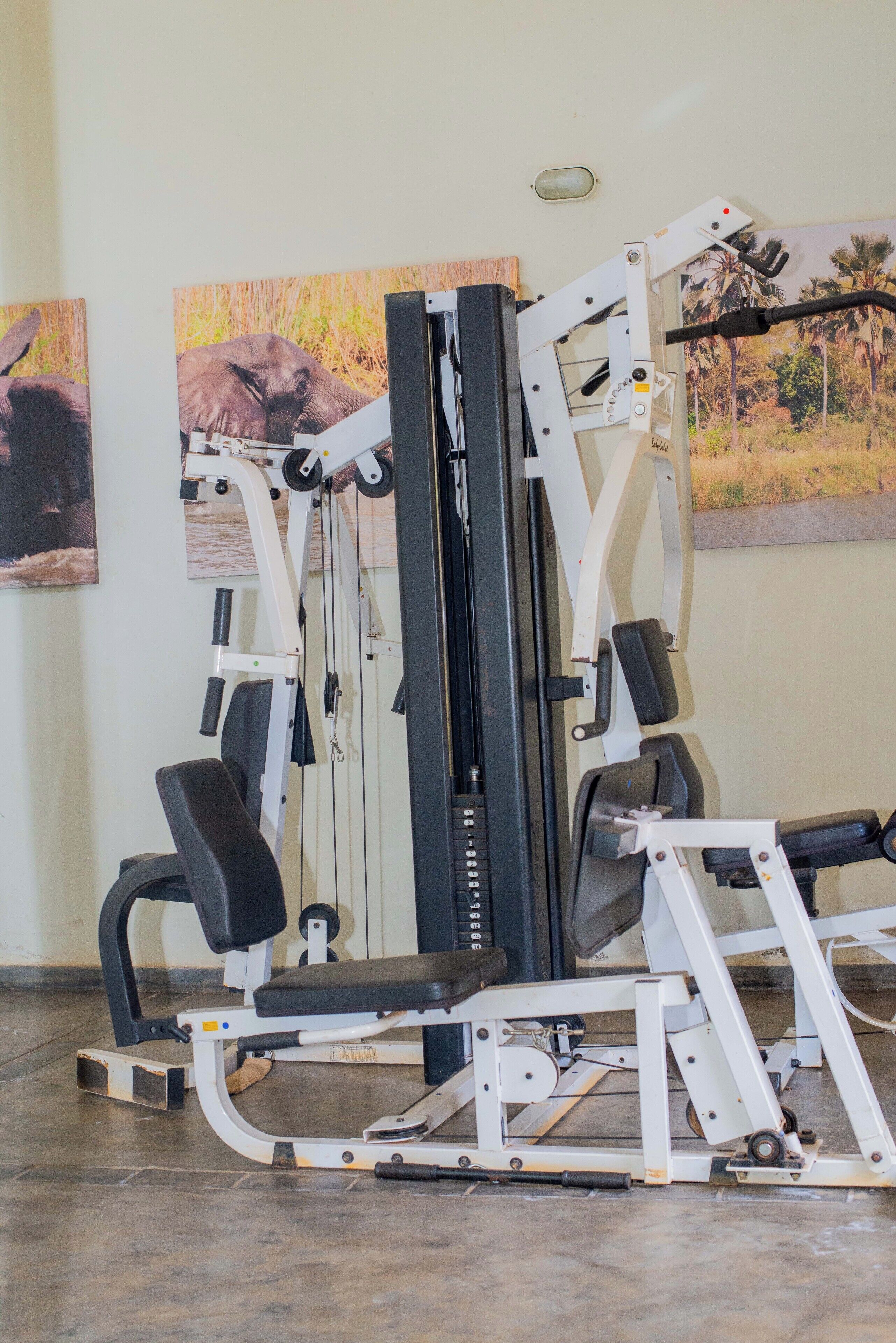Un gimnasio con una máquina de pesas y un banco.