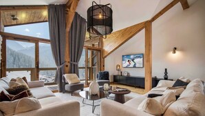 A cozy living room with a large window, a fireplace, and a comfortable seating area.