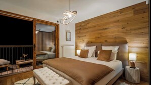 A modern bedroom with a large bed, wooden headboard, and a unique pendant light.