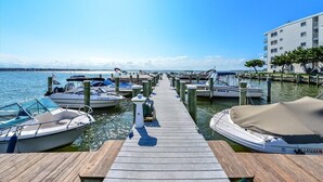 Un port de plaisance avec des bateaux amarrés, une jetée en bois et un bâtiment doté de balcons.