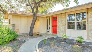 A house with a red door, stone exterior, and a gravel driveway. - Large Yard: Home 9 Mi to San Antonio River Walk (San Antonio)
