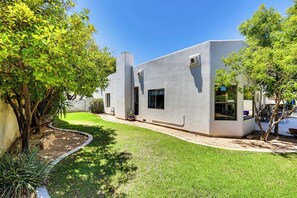 A modern house with a well-maintained lawn and a few trees.