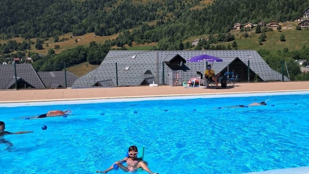 Une piscine offrant une vue sur les montagnes et les maisons au loin.