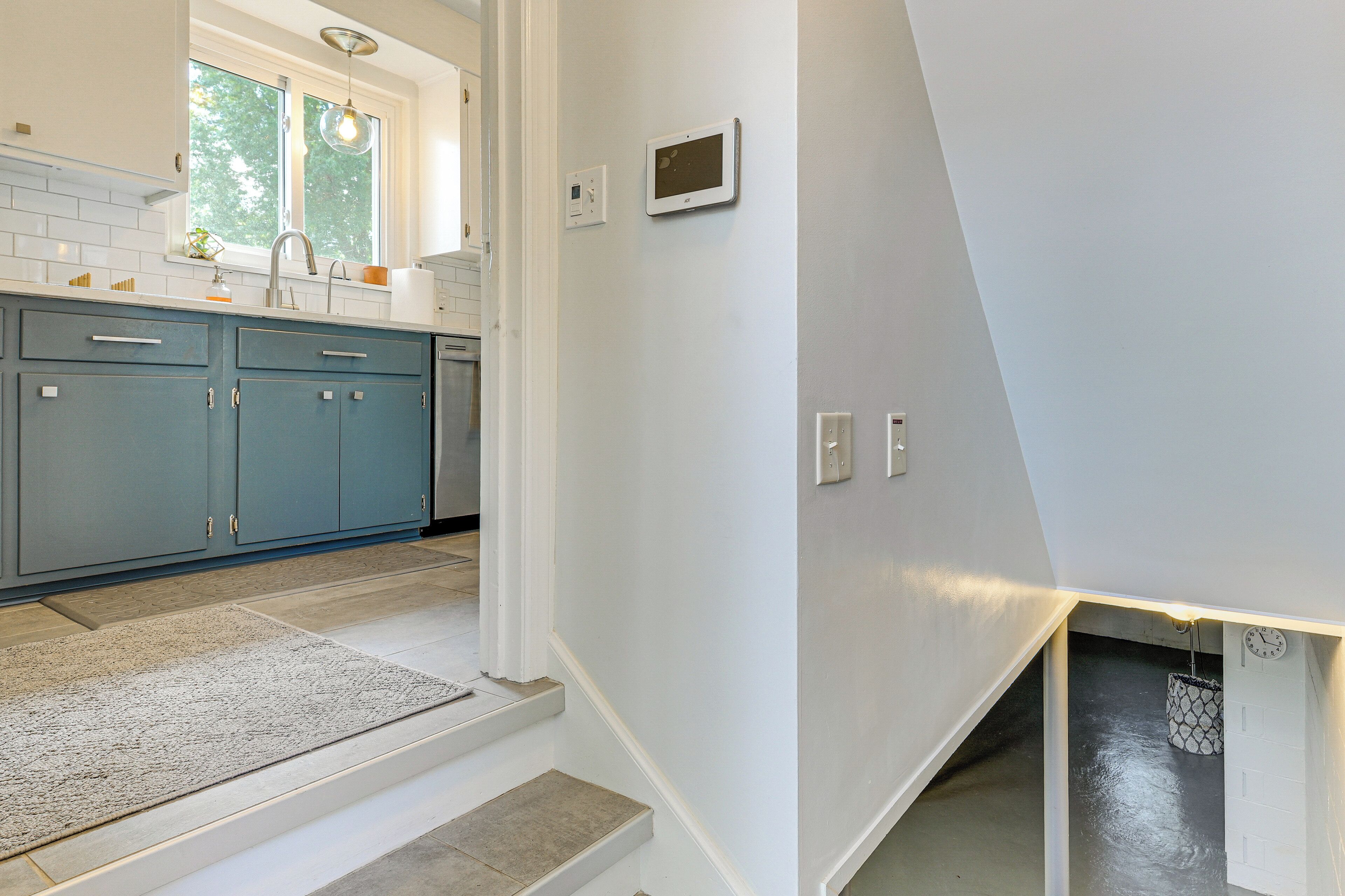 A modern kitchen with blue cabinets, a white countertop, and a built-in oven.