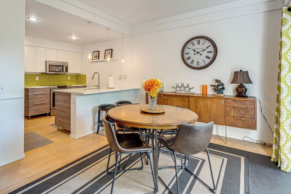A modern kitchen with a central island, wooden cabinets, and a clock on the wall. - Modern Home Close to Dtwn Woodinville w/ Yard (Woodinville)