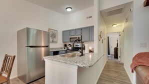 A modern kitchen with a stainless steel refrigerator, granite countertop, and a built-in oven. - 0.5 Mi to Table Rock Lake: Ozark Mountains Cabin (Kimberling City)