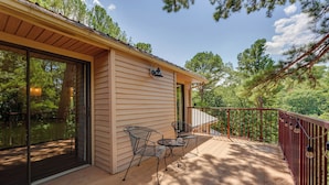 A wooden deck with a glass door leading to a room, a metal chair, and a small table. - 0.5 Mi to Table Rock Lake: Ozark Mountains Cabin (Kimberling City)