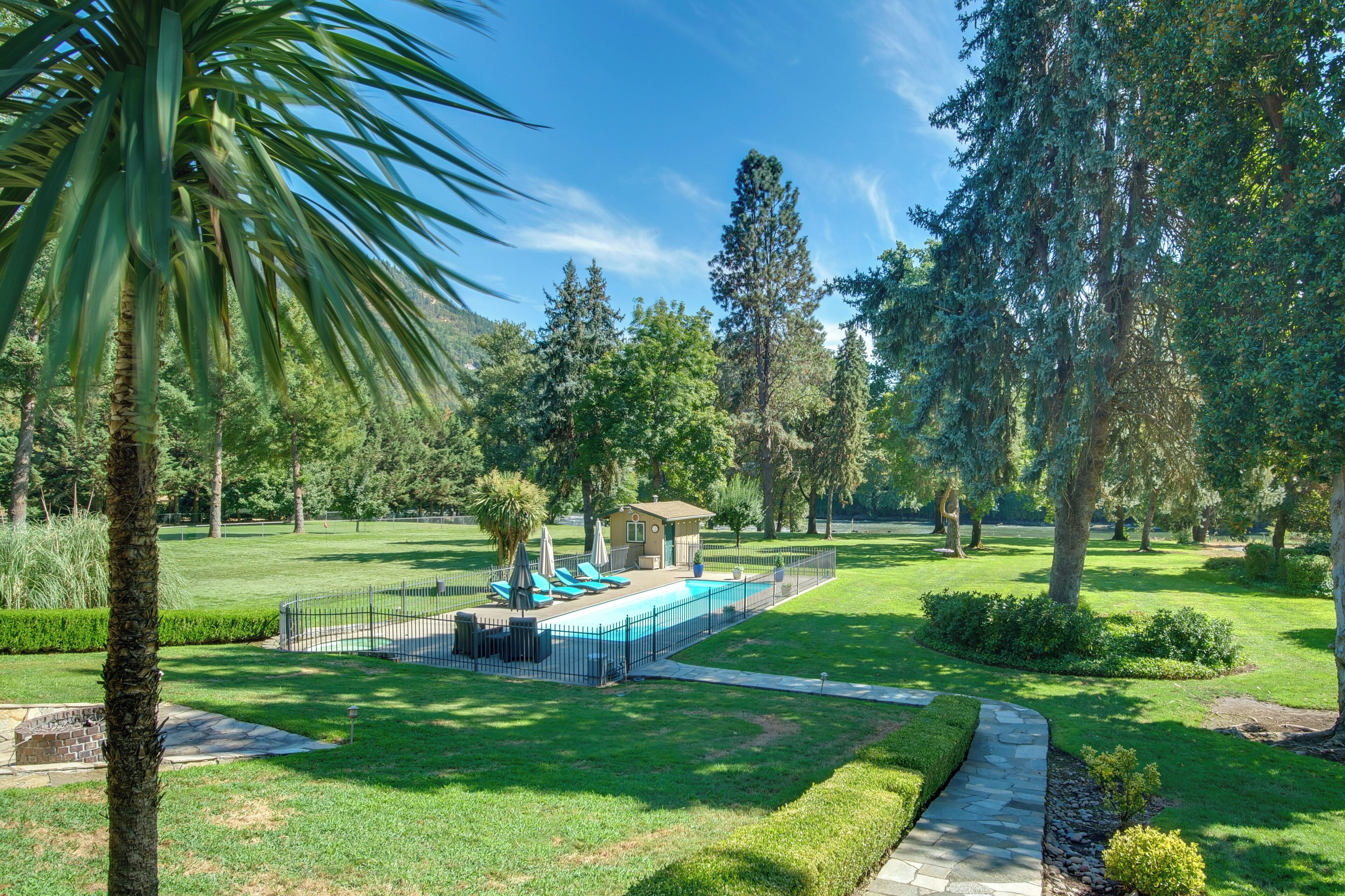 A well-maintained park with a swimming pool, lounge chairs, and a small pavilion.
