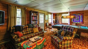A cozy room with a plaid sofa, armchair, and a pool table. - Deck, Fire Pit, Games: Family Escape Near Boone (Zionville)