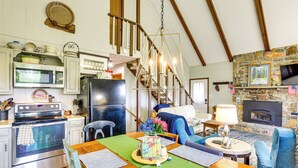 A spacious kitchen with modern appliances, a dining area with a wooden table, and a cozy living room with a fireplace. - Deck, Fire Pit, Games: Family Escape Near Boone (Zionville)