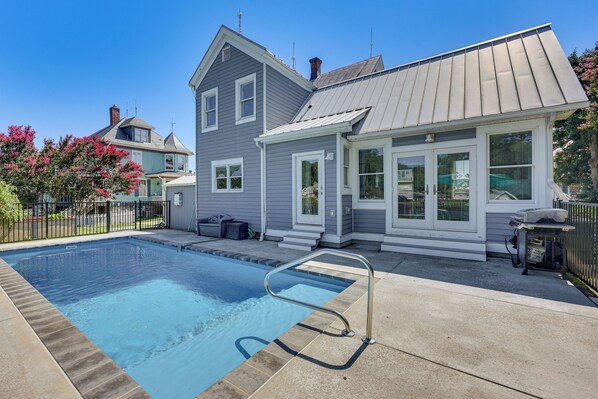 A residential swimming pool with a metal safety ladder, surrounded by a concrete deck. - Historic Waterfront Home w/ Dock in Reedville! (Reedville)