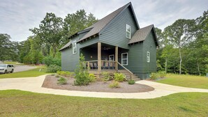 A two-story house with a porch and a small garden area. - Walk to Lake Martin: Water-view Retreat w/ Deck! (Tallassee)