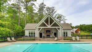 A pool area with a stone fireplace and outdoor seating. - Walk to Lake Martin: Water-view Retreat w/ Deck! (Tallassee)