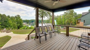 A covered outdoor deck with four chairs, a table, and a ceiling fan. - Walk to Lake Martin: Water-view Retreat w/ Deck! (Tallassee)