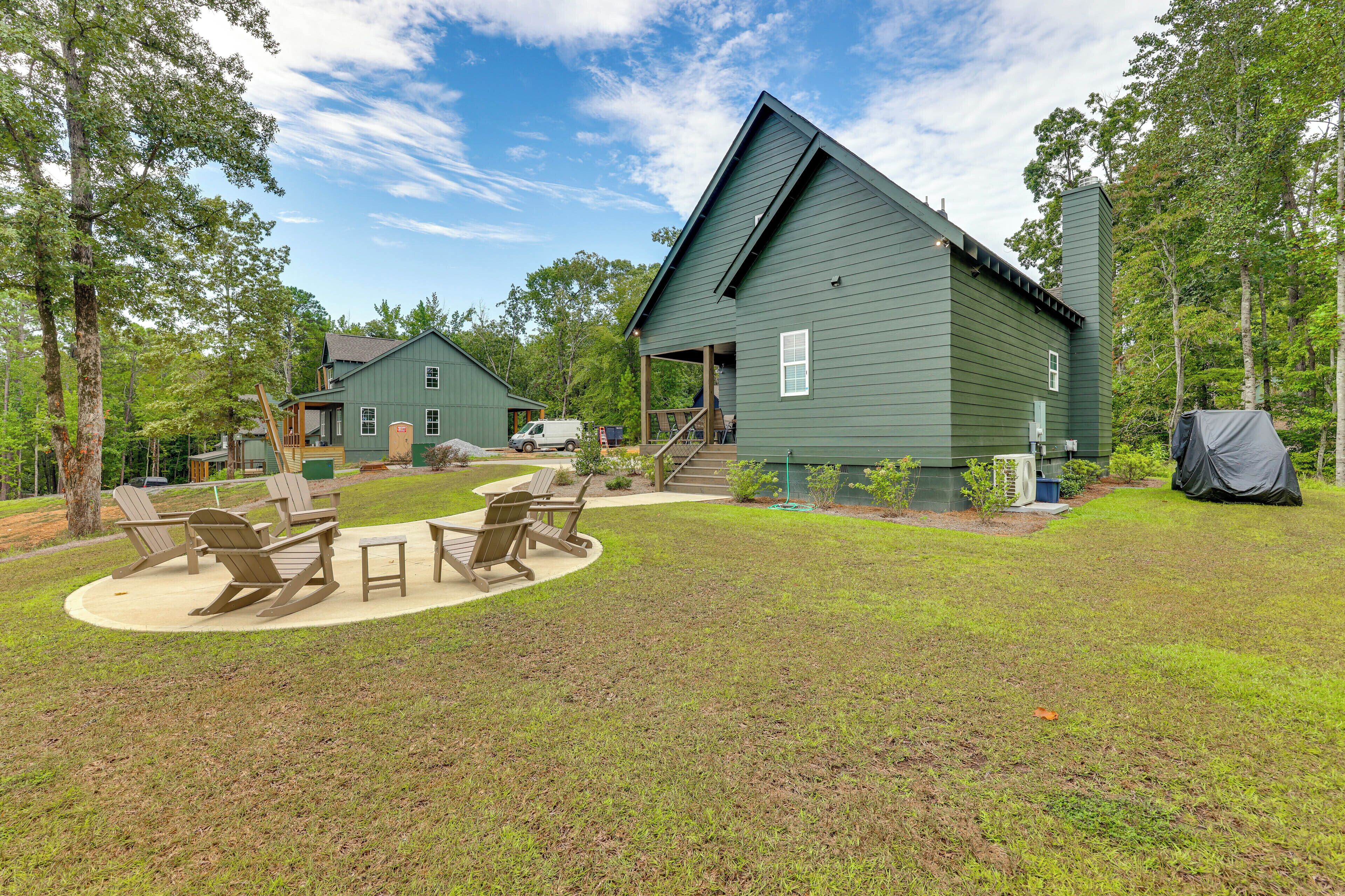 A green building with a covered deck and outdoor seating area.