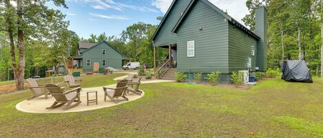 A green building with a covered deck and outdoor seating area.