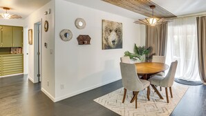 A dining area with a wooden table and chairs, a large bear artwork, and a ceiling with wooden slats. - Modern Creekside Retreat 1 Mi to Spirit Mtn Casino (Grand Ronde)