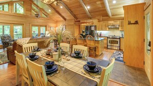 A spacious wooden cabin with a dining area set for a meal, a kitchen with modern appliances, and a cozy living room with a fireplace. - Luxe Mountain Escape w/ Hot Tub & Gym Near Boone! (Zionville)