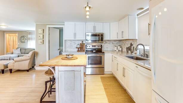 A modern kitchen with white cabinets, stainless steel appliances, and a wooden island. - Pet-friendly Harrison Home: 1 Mi to Wilson St Park (Harrison)