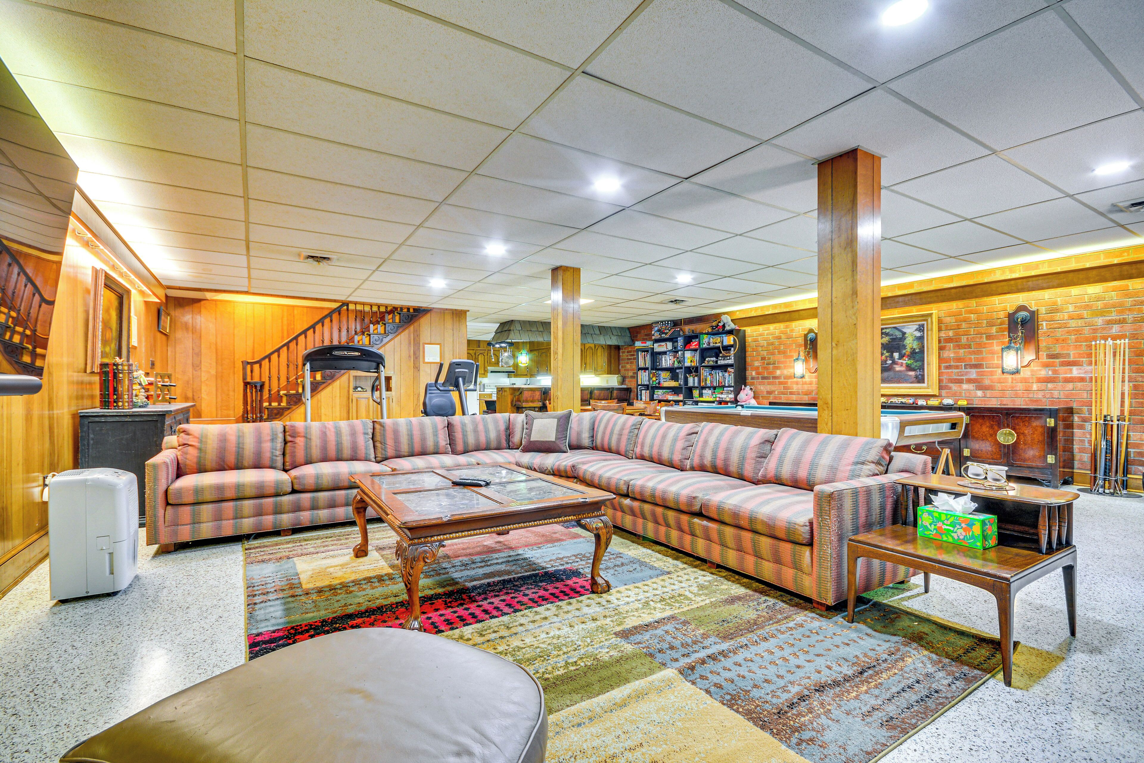 A spacious living room with a large sectional sofa, a coffee table, and a fireplace.