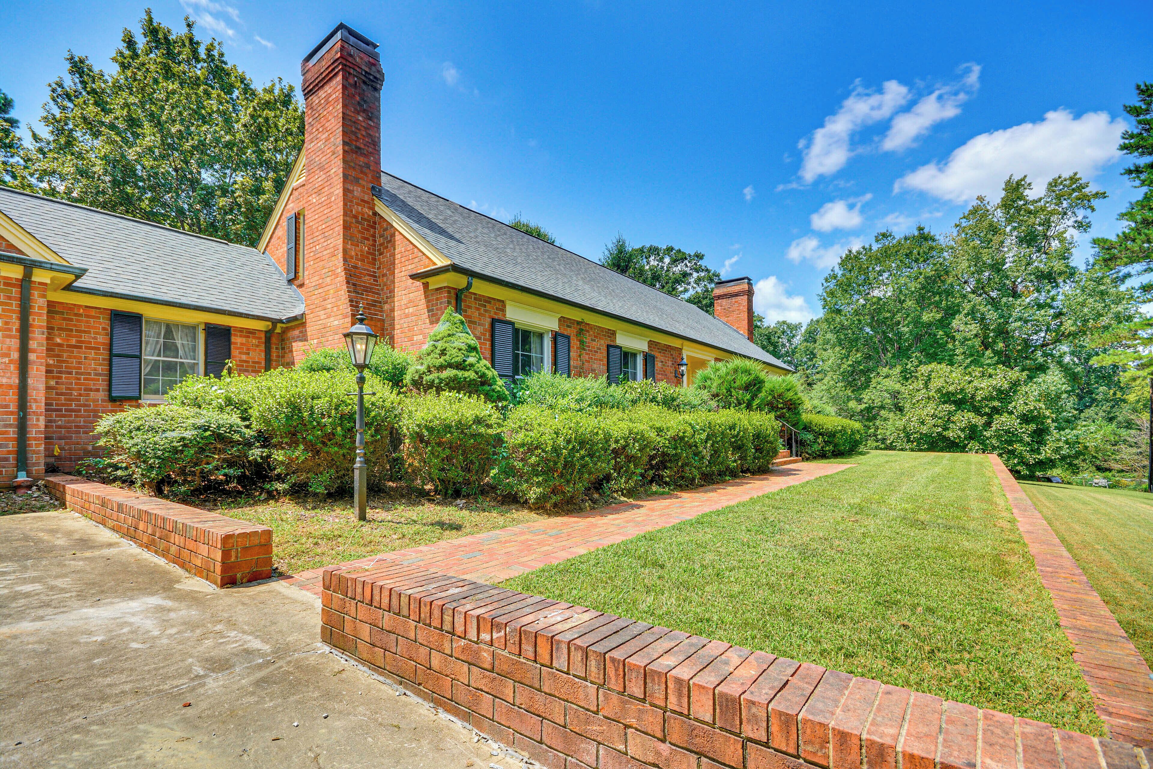 A brick building with a well-maintained lawn and a brick pathway leading to the entrance.