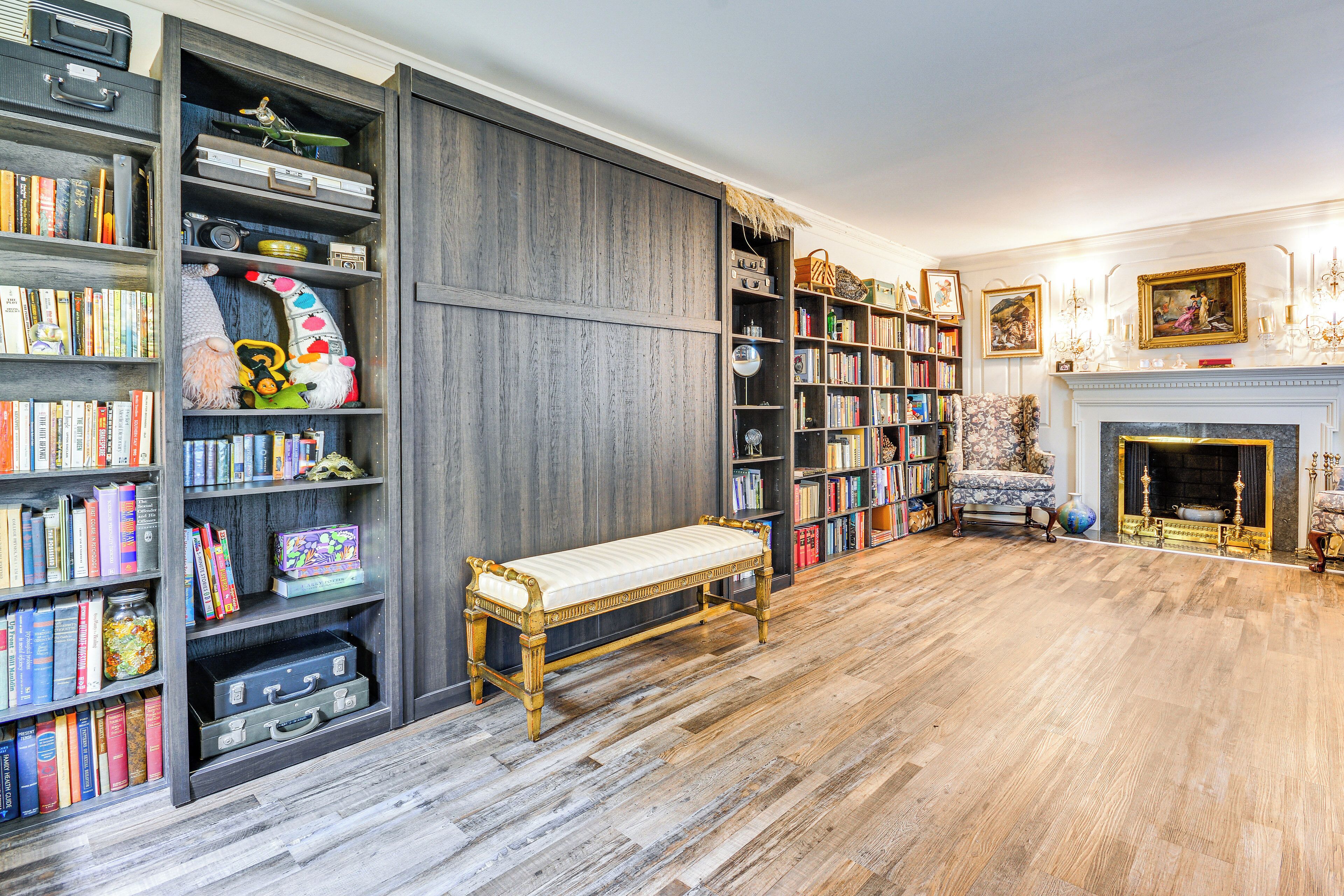 Ein Zimmer mit Holzboden, einer Bank und einem Kamin.