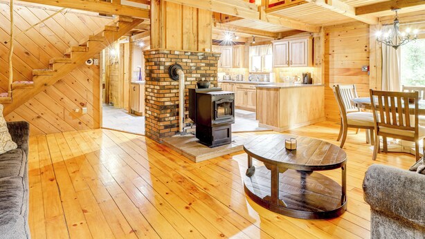 A cozy log cabin interior with a fireplace, wooden floors, and a dining area. - 7 Mi to Glens Falls: Peaceful Retreat w/ Game Room (Hudson Falls)