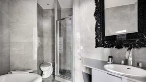 Een moderne badkamer met een bad, douchecabine, toilet en een wastafelmeubel met een wastafel.